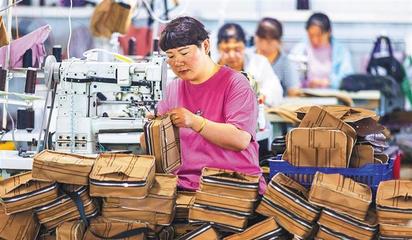 阜平縣顧家臺村九歌皮具有限公司,村民在加工箱包。當地生產的箱包通過線上線下俏銷全國各地。